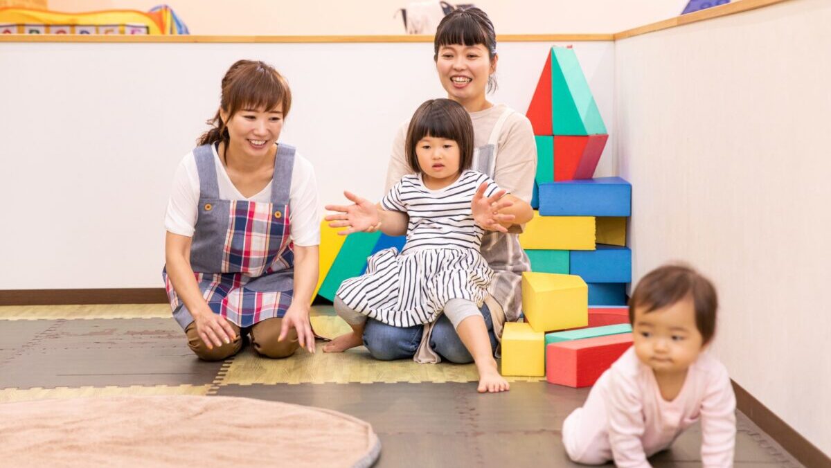 保育園で先生と子どもが遊んでいる風景